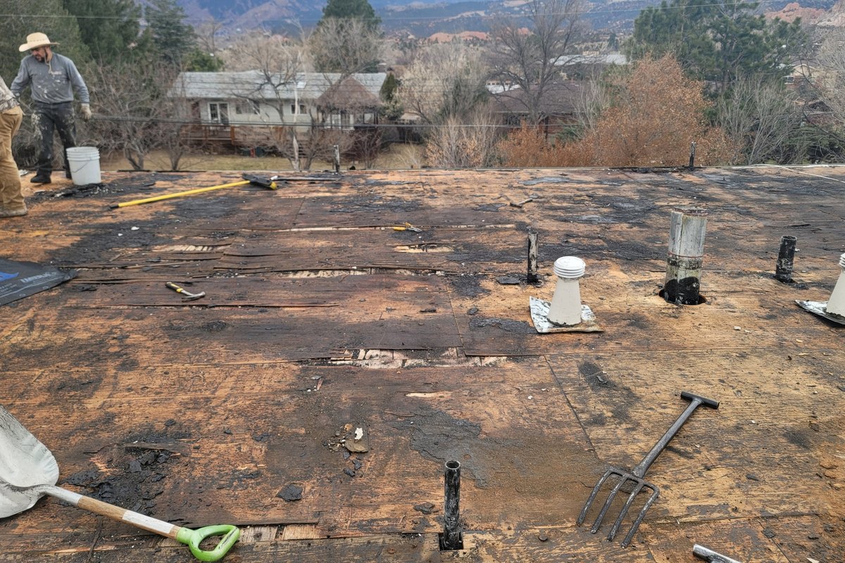 Stripped roof deck with tools and pipe penetrations