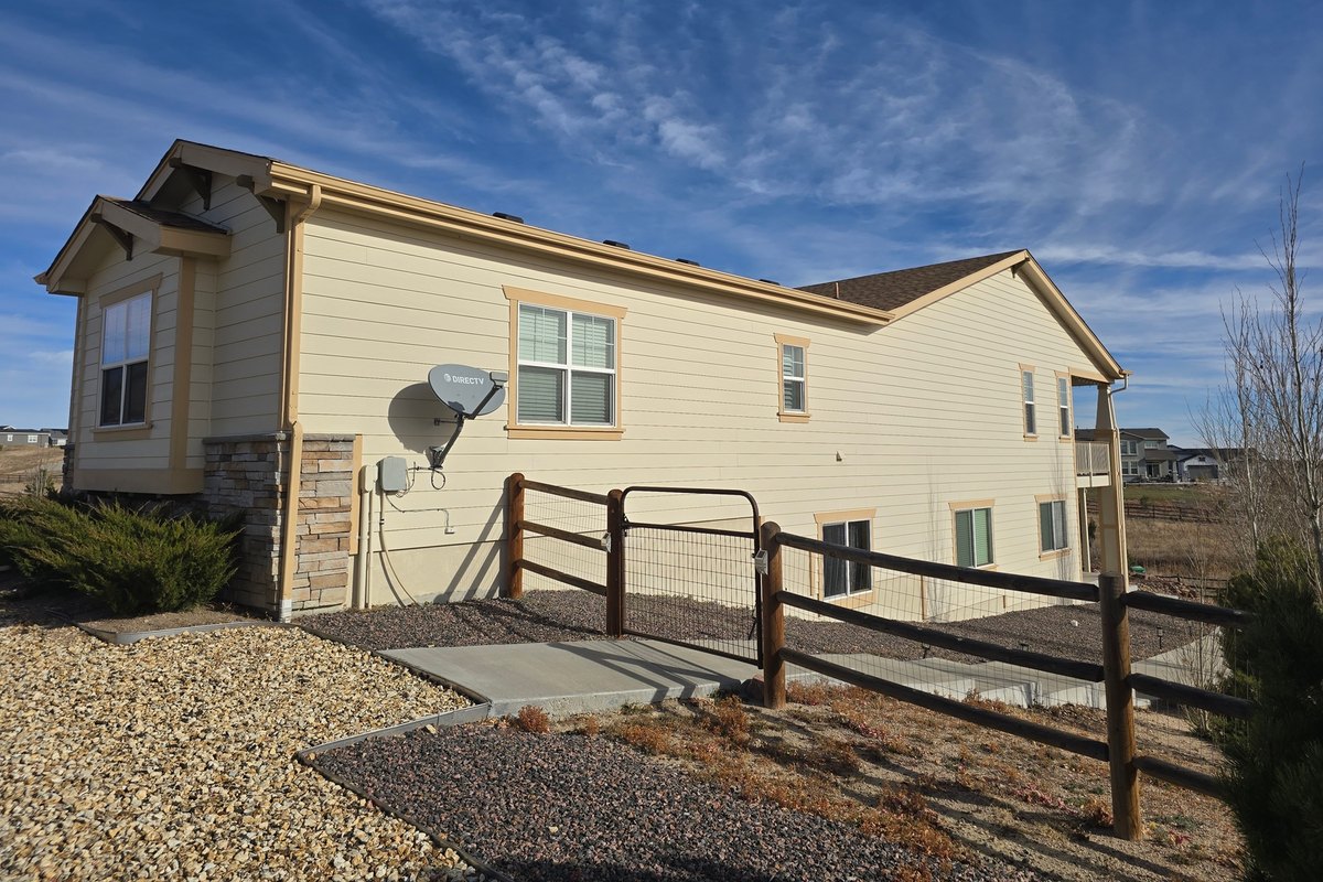 Tan single-story house with lap siding across the front and gable end