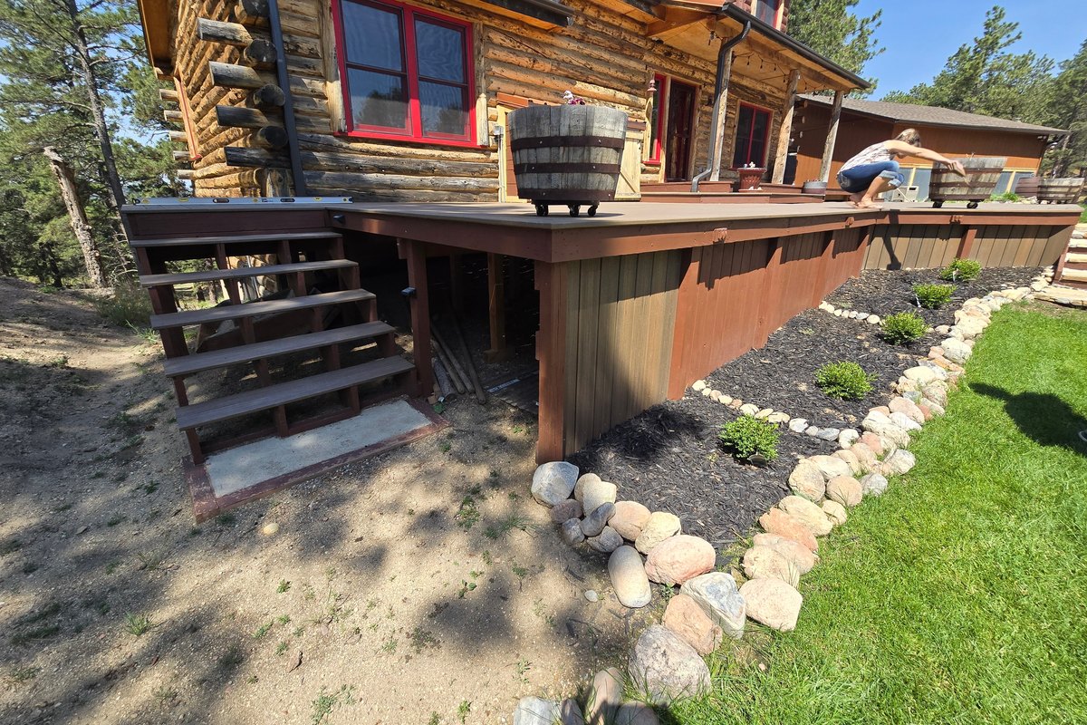 Log home with a newly built deck and stained timber stairs